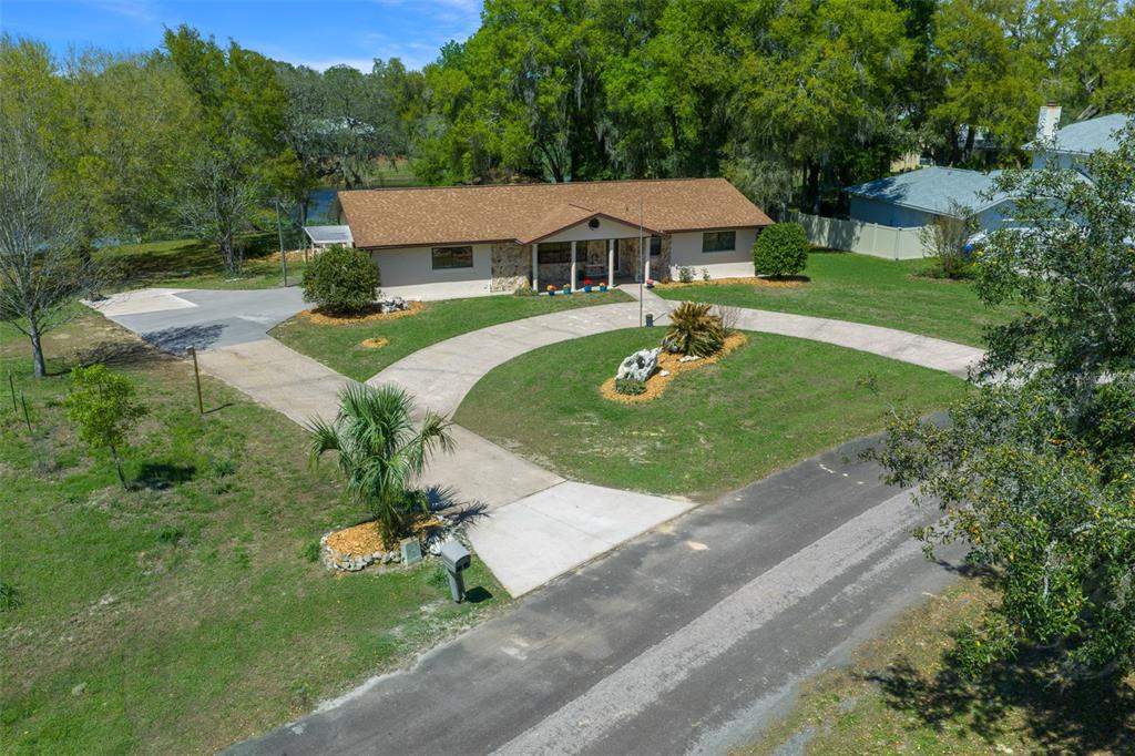 9923 East St Regis Court Inverness, FL 34450 - Photo 17 of 76 a view of a white house with a yard table and chairs