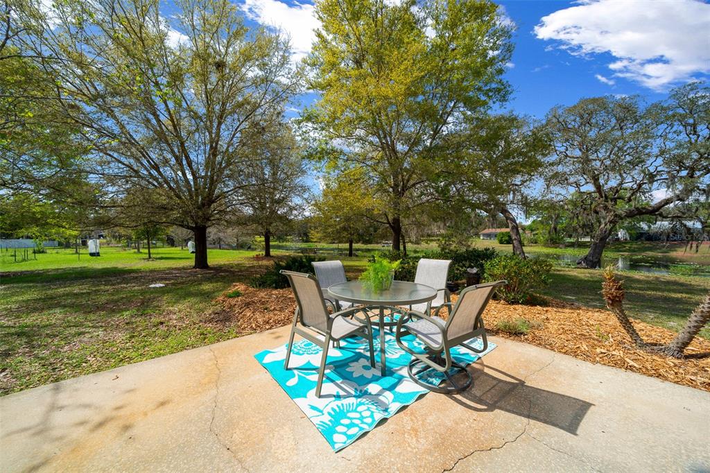 9923 East St Regis Court Inverness, FL 34450 - Photo 24 of 76 a view of a lake with a table and chairs under an umbrella
