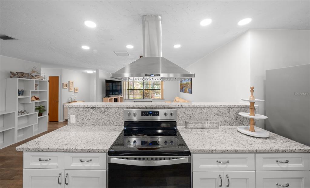9923 East St Regis Court Inverness, FL 34450 - Photo 47 of 76 a kitchen with granite countertop stainless steel appliances a stove cabinets and wooden floor