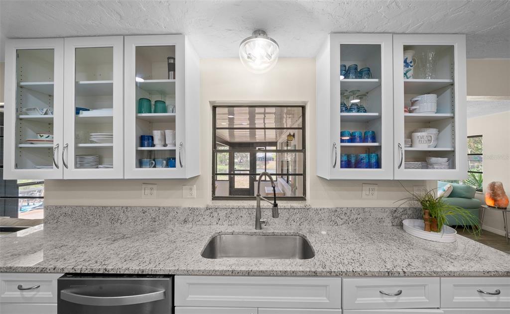 9923 East St Regis Court Inverness, FL 34450 - Photo 48 of 76 a kitchen with granite countertop a sink and a window
