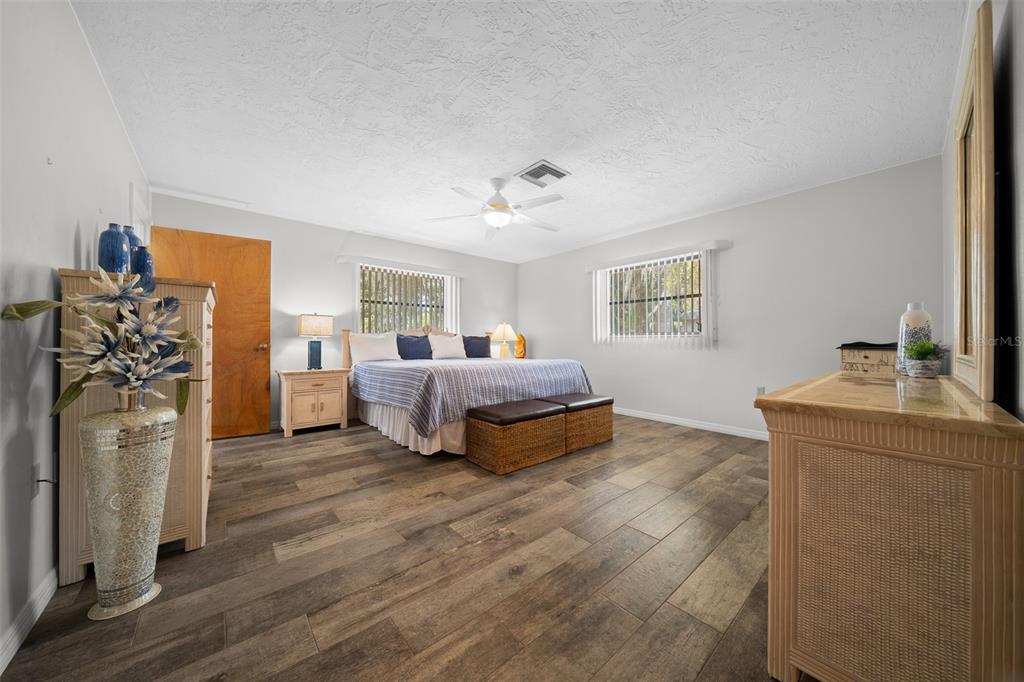 9923 East St Regis Court Inverness, FL 34450 - Photo 70 of 76 a spacious bedroom with a bed and a chandelier