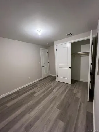 an empty room with closet and mirror
