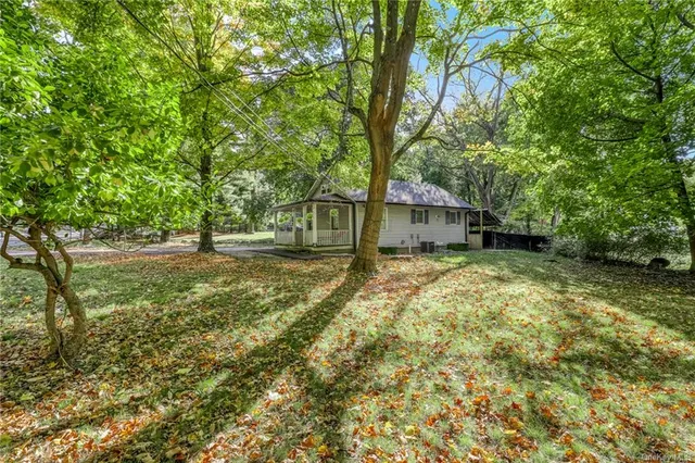 a view of a house with backyard and tree