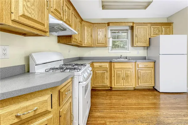 a kitchen with stainless steel appliances granite countertop a sink a stove and a refrigerator
