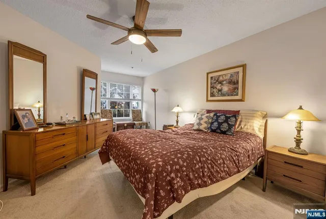 a bedroom with a large bed and a chandelier fan