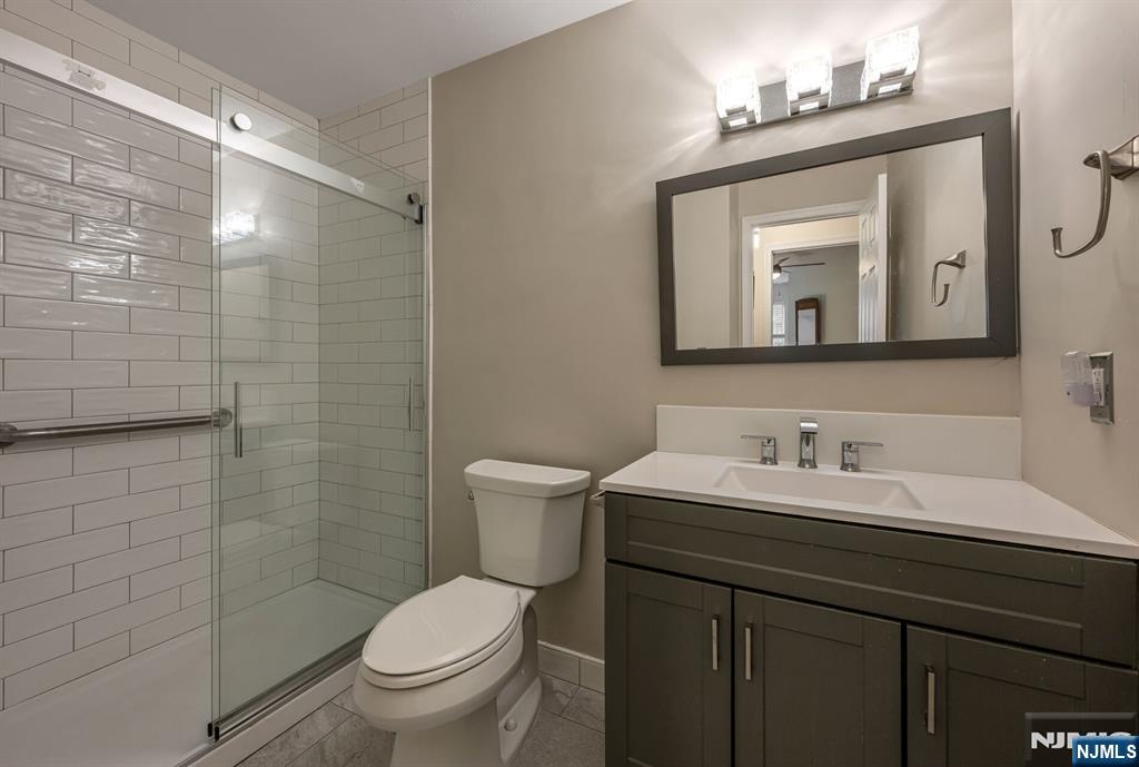 1155 Garrison Court Mahwah, NJ 07430 - Photo 17 of 26 a bathroom with a toilet sink vanity and mirror