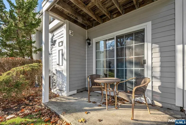a patio with table and chairs and potted plants