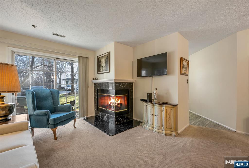 1155 Garrison Court Mahwah, NJ 07430 - Photo 4 of 26 a living room with furniture a flat screen tv and a fireplace