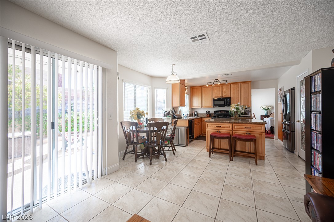 718 Rusty Spur Drive Henderson, NV 89014 - Photo 15 of 50 A well-appointed kitchen and dining area features abundant cabinetry and tiled flooring, perfect for daily living.