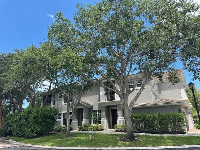 1315 Remington Way, Unit 1201 Naples, FL 34110 - Photo 13 of 20 Traditional-style home with stucco siding, a balcony, and a front lawn