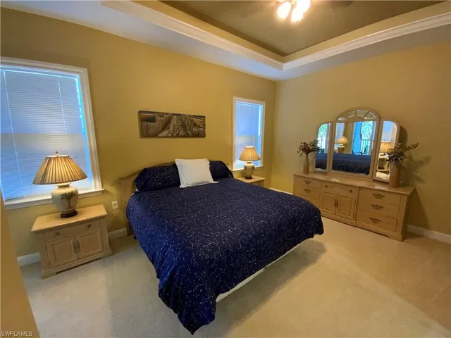 a bedroom with a bed and dresser with chair