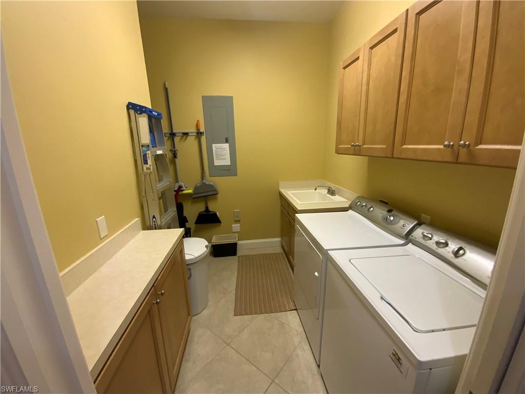 1315 Remington Way, Unit 1201 Naples, FL 34110 - Photo 8 of 20 Washroom featuring washer and clothes dryer, electric panel, light tile patterned flooring, and cabinet space