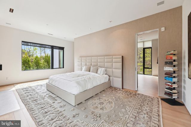 a bed sitting in a spacious bedroom next to a window