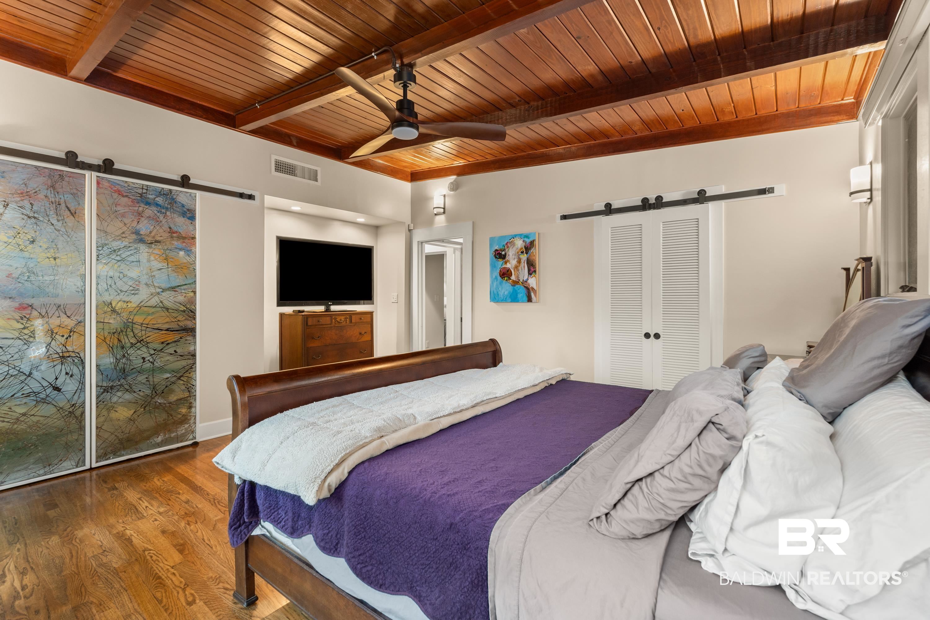 233 Suzanne Circle Mobile, AL 36608 - Photo 24 of 85 Bedroom with a barn door, wood finished floors, a wooden ceiling with exposed beams, and ceiling fan