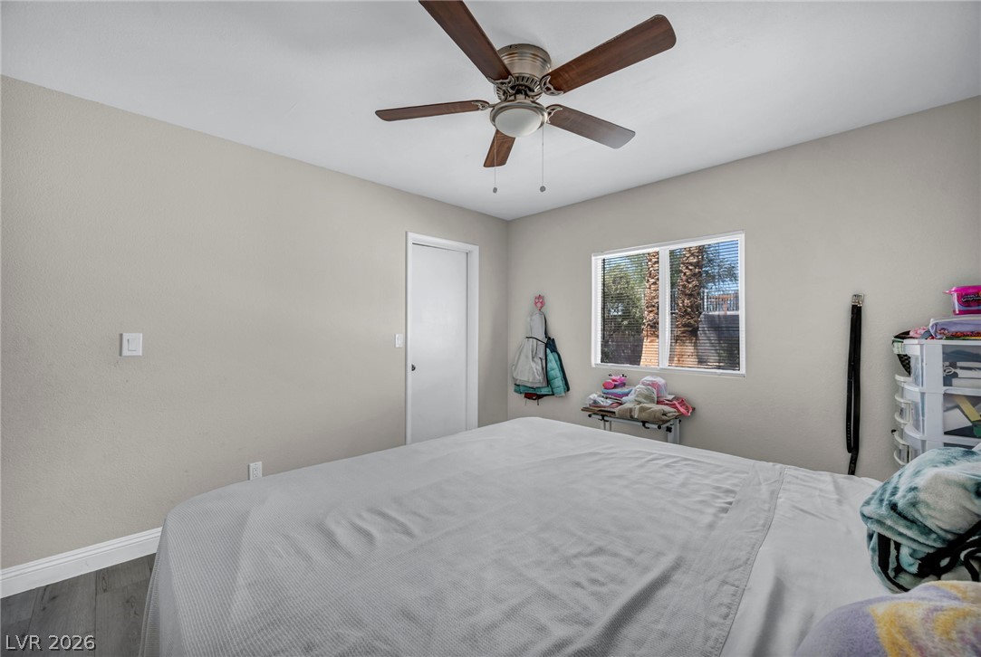 5882 Rio Tinto Way Las Vegas, NV 89110 - Photo 16 of 56 A well-lit bedroom provides comfortable living with hardwood-style flooring and a ceiling fan for climate control.