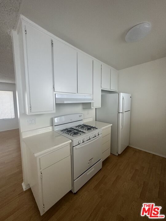 11525 Rochester Avenue, Unit 201 Los Angeles, CA 90025 - Photo 5 of 12 a kitchen with stainless steel appliances granite countertop a stove a refrigerator and a microwave