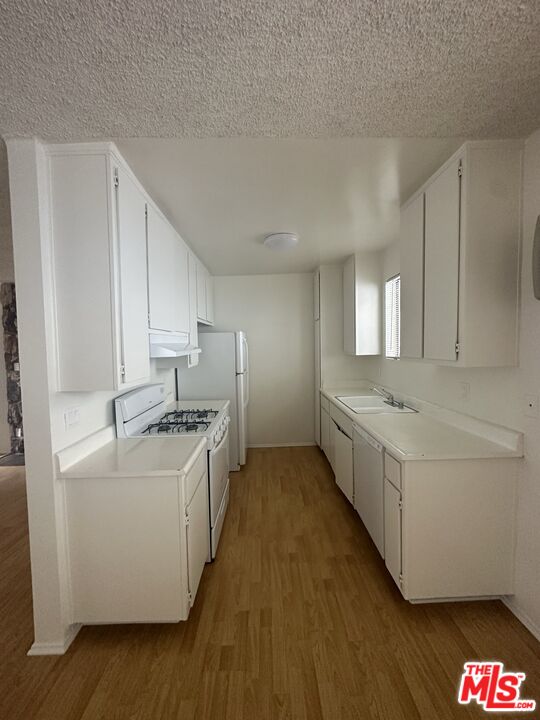 11525 Rochester Avenue, Unit 201 Los Angeles, CA 90025 - Photo 6 of 12 a large white kitchen with cabinets and wooden floor
