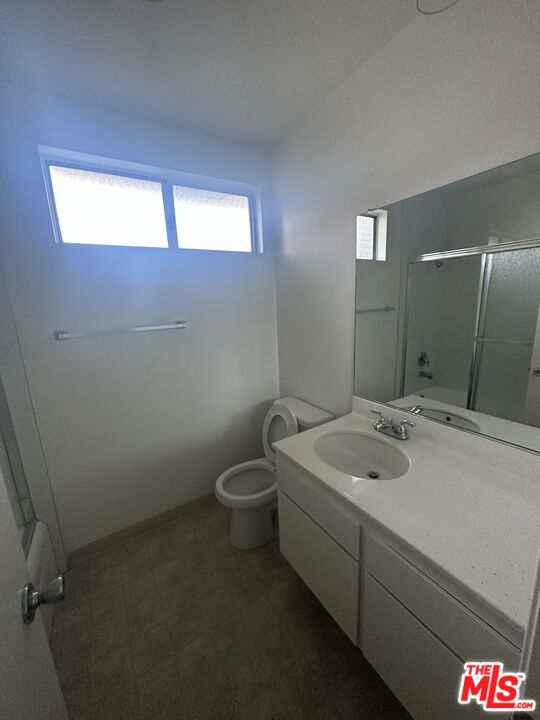 11525 Rochester Avenue, Unit 201 Los Angeles, CA 90025 - Photo 9 of 12 a bathroom with a toilet sink and mirror