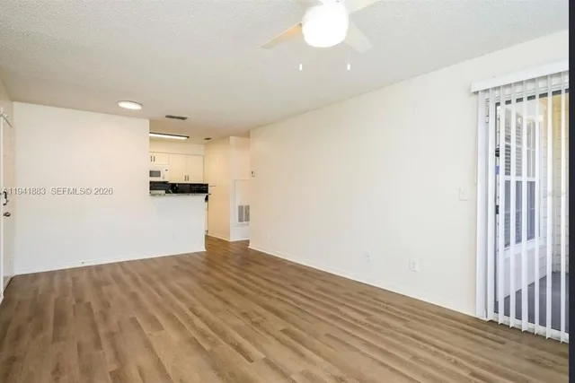 a view of empty room with wooden floor