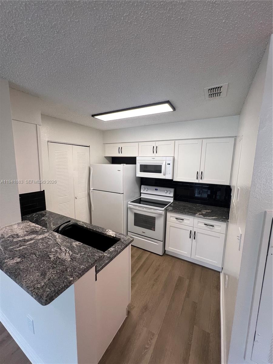 1055 South Hiawassee Road, Unit 2014 Orlando, FL 32835 - Photo 17 of 22 a kitchen with a refrigerator and a stove top oven