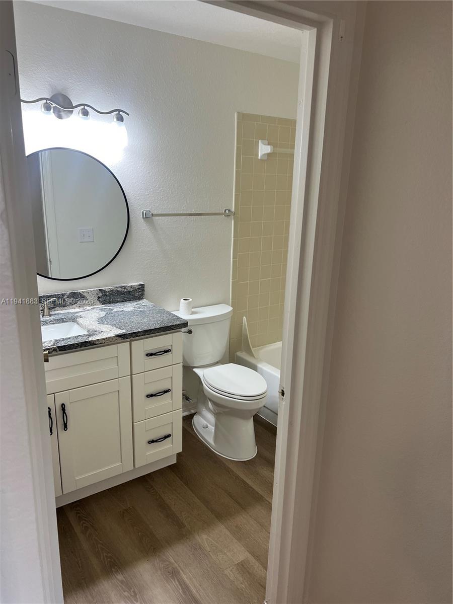 1055 South Hiawassee Road, Unit 2014 Orlando, FL 32835 - Photo 20 of 22 a bathroom with a granite countertop toilet sink mirror and vanity