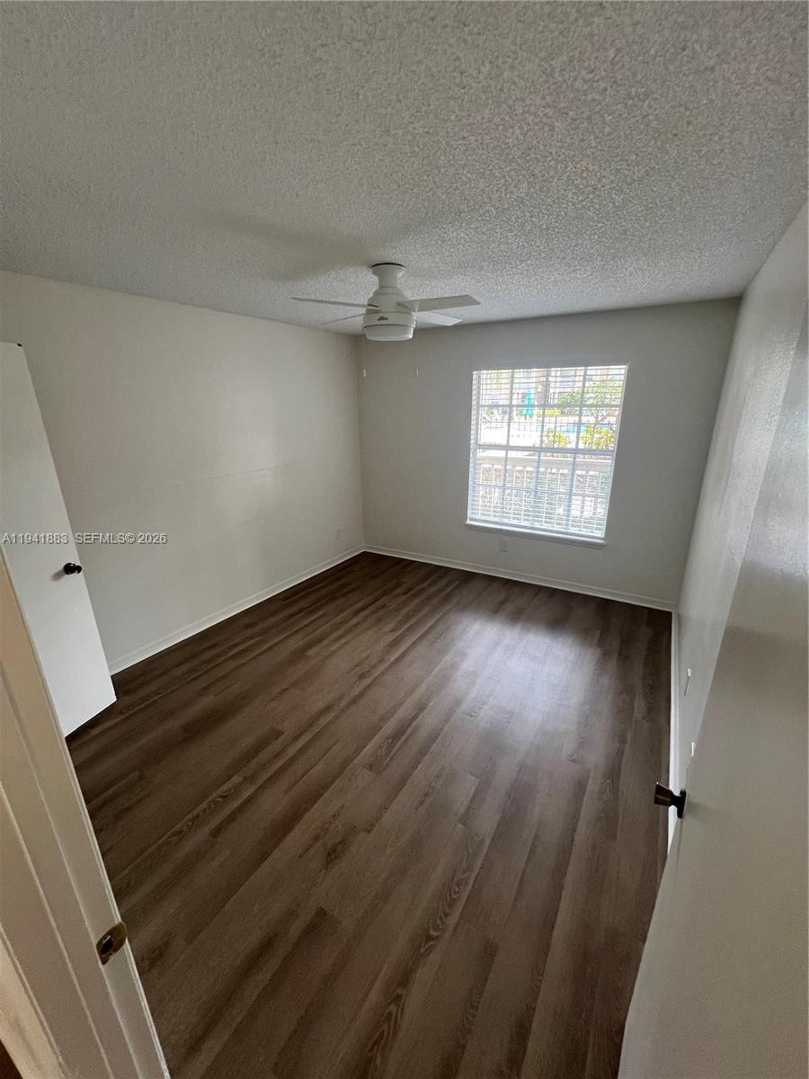 1055 South Hiawassee Road, Unit 2014 Orlando, FL 32835 - Photo 4 of 22 an empty room with wooden floor fan and windows