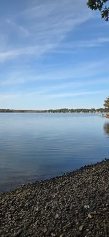 an empty room with wooden floor fireplace and windows
