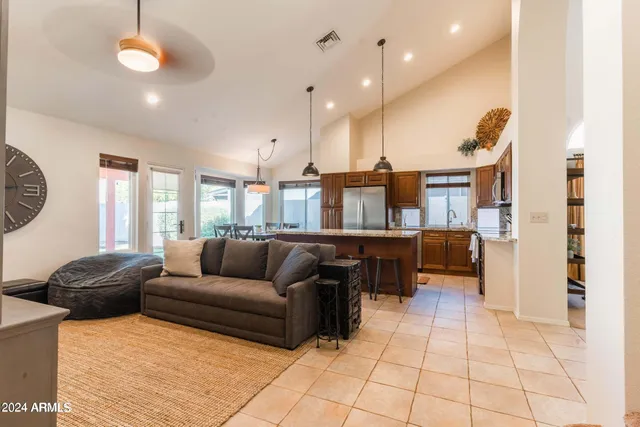 a kitchen with stainless steel appliances granite countertop a stove a sink a microwave a dining table and chairs