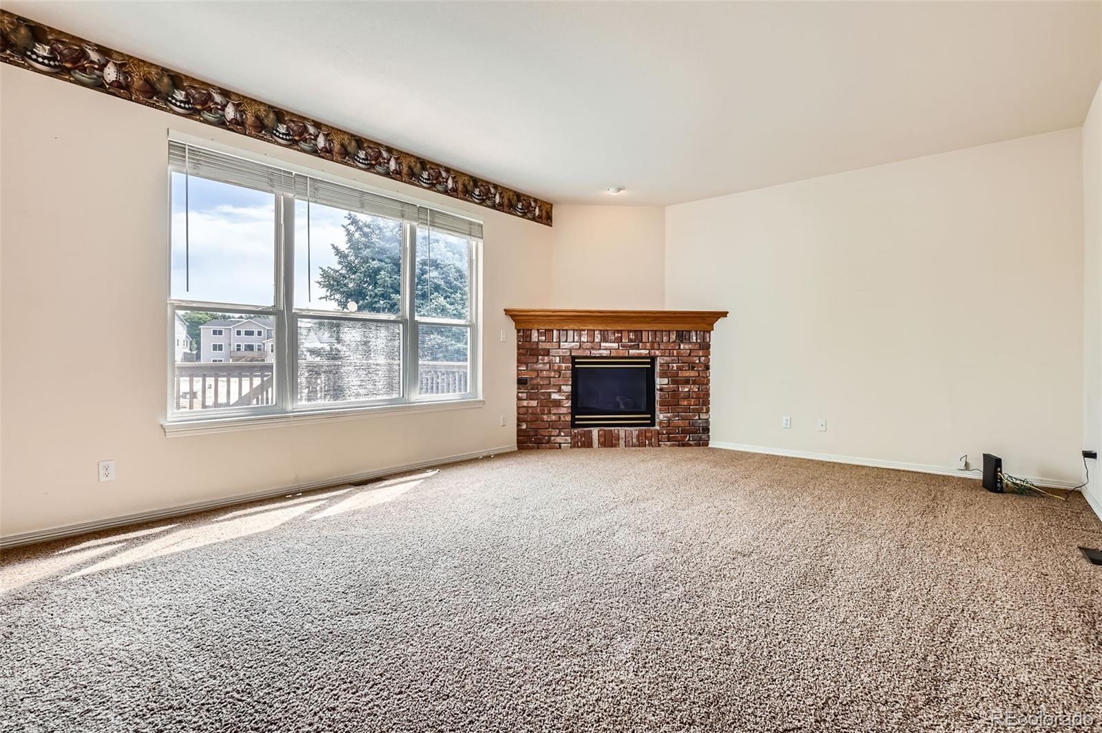 2561 Cactus Bluff Place Highlands Ranch, CO 80129 - Photo 15 of 33 a view of an empty room with a fireplace and a window