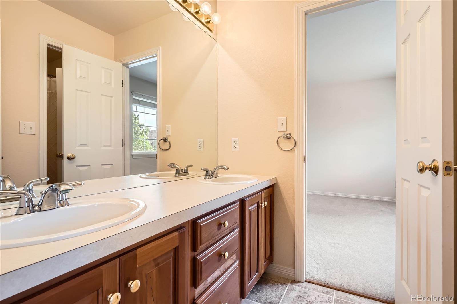 2561 Cactus Bluff Place Highlands Ranch, CO 80129 - Photo 25 of 33 a bathroom with a sink double vanity and a mirror