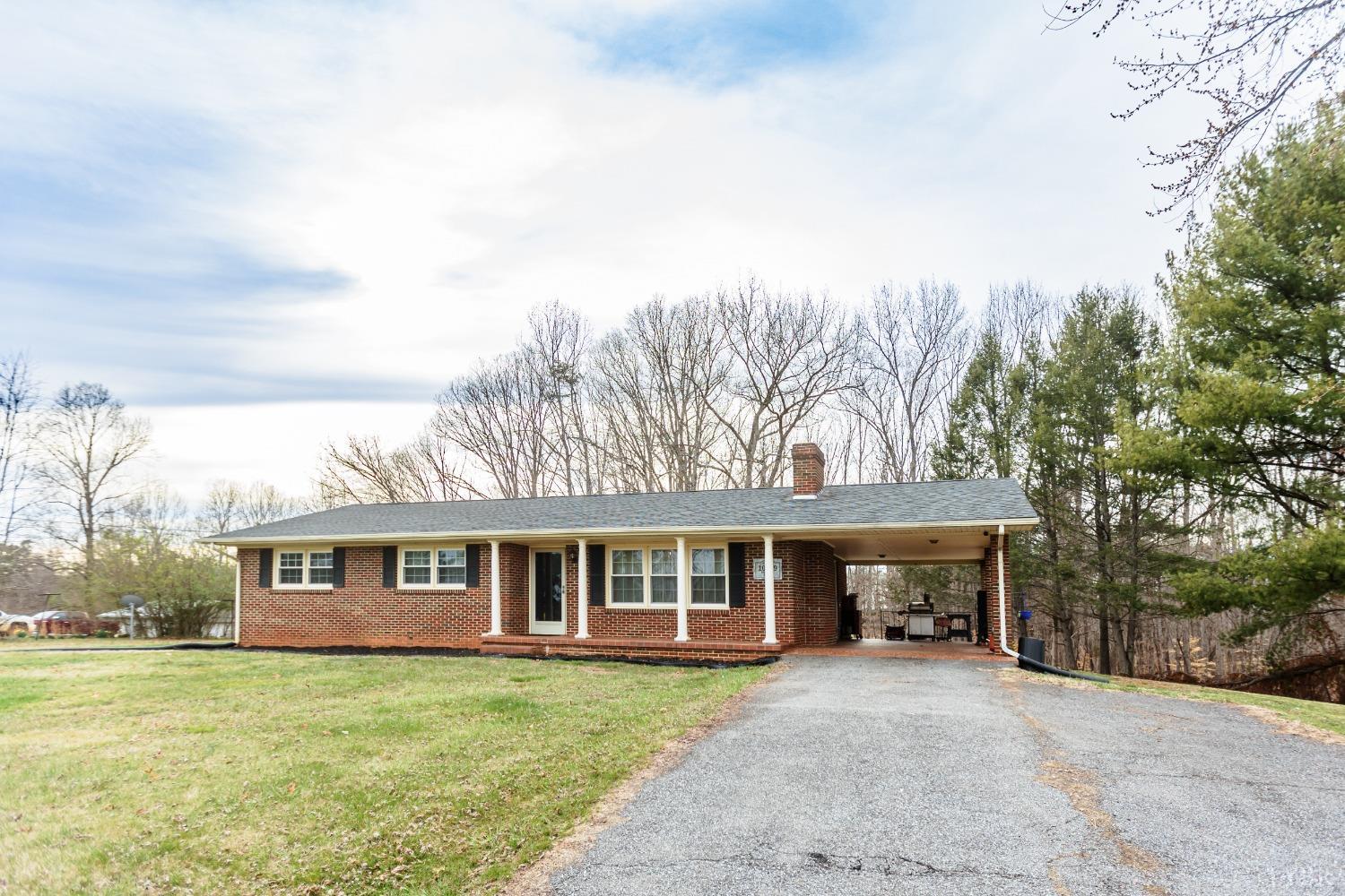 a front view of a house with a garden and trees