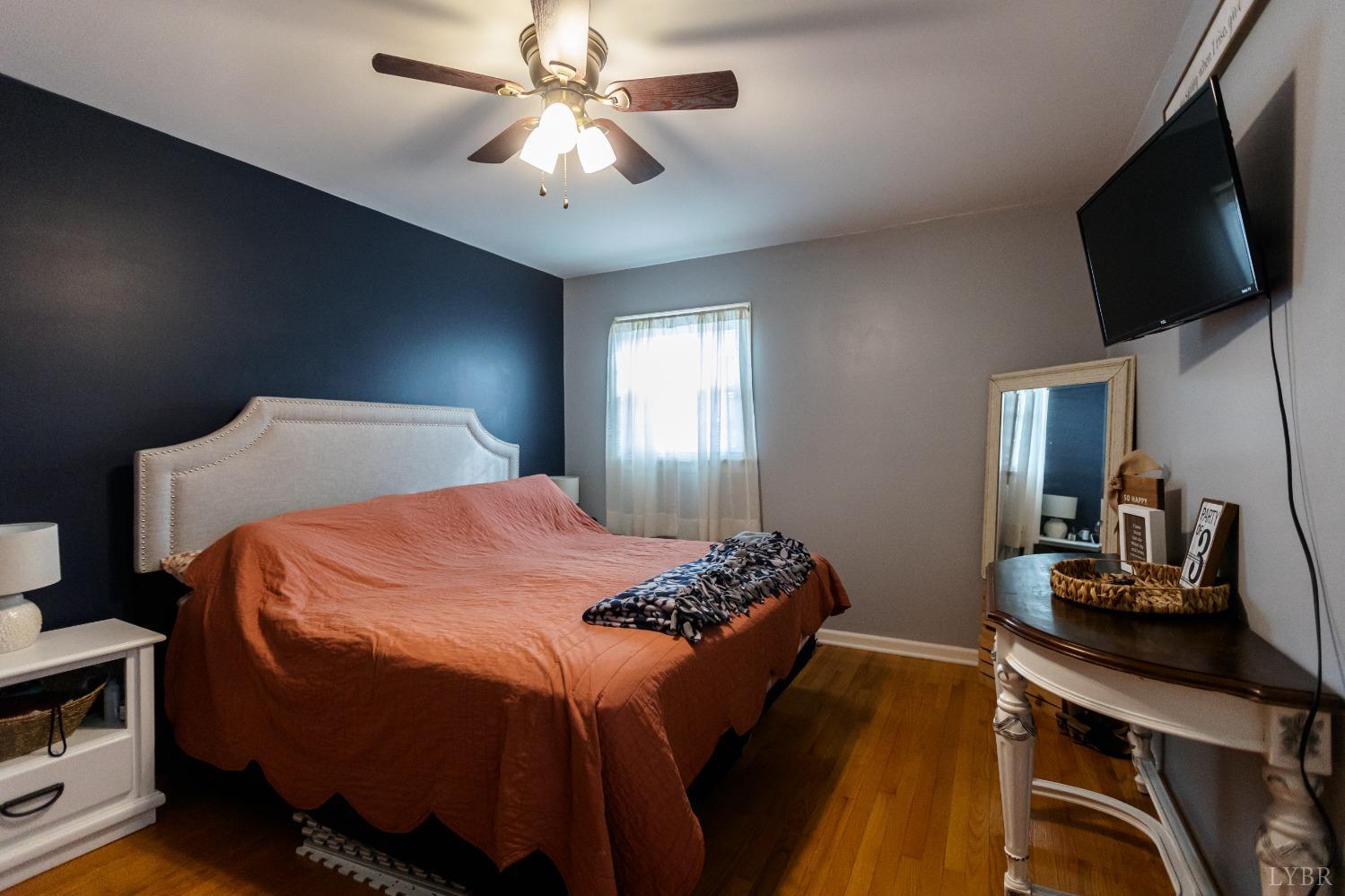 10769 Oakville Road Gladstone, VA 24553 - Photo 16 of 35 a bedroom with a large bed and a flat tv screen on a dresser