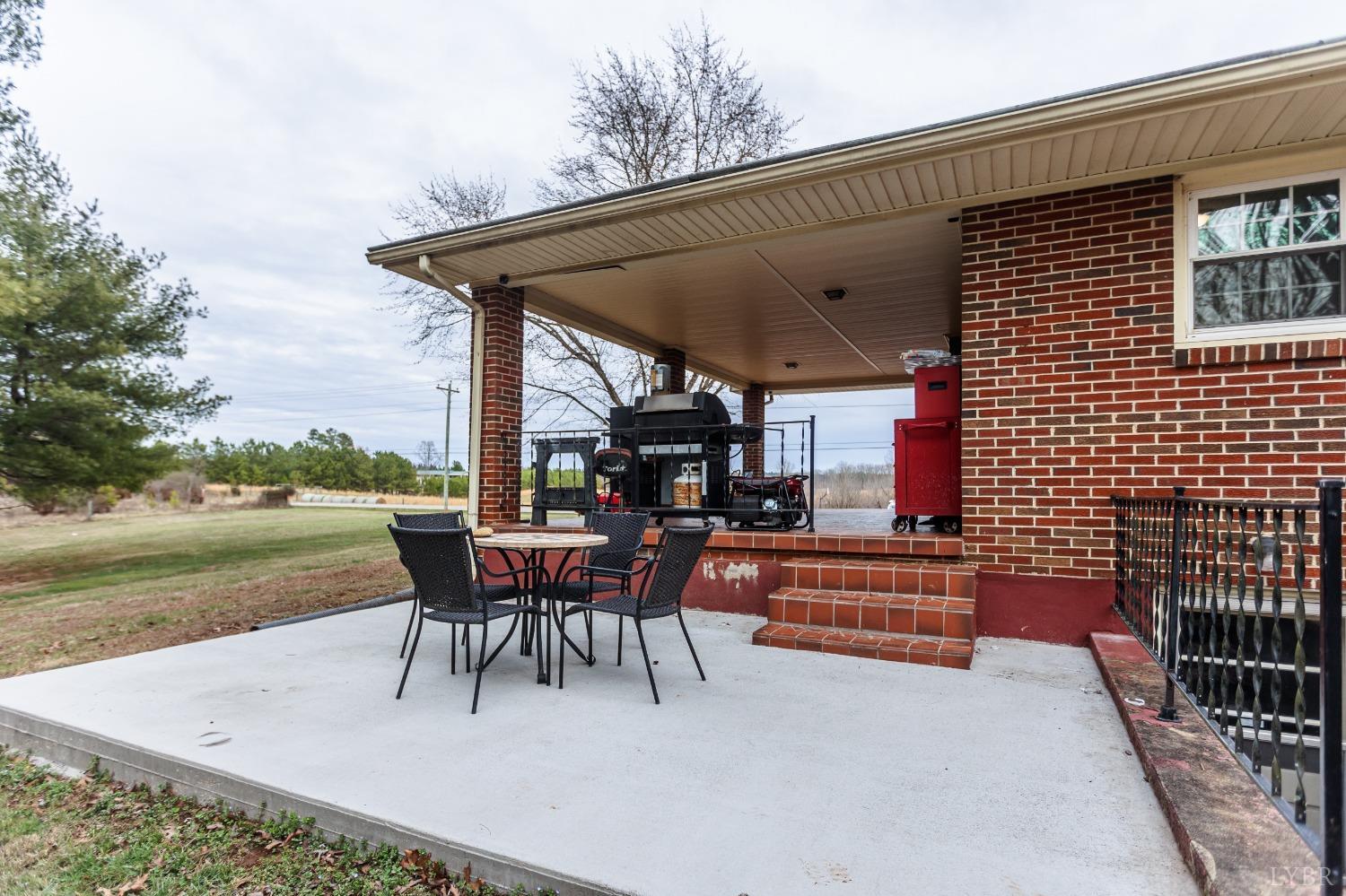 10769 Oakville Road Gladstone, VA 24553 - Photo 30 of 35 a view of a patio with a table chairs and a backyard