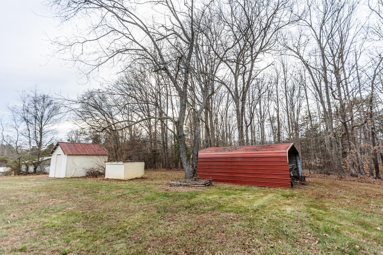 10769 Oakville Road Gladstone, VA 24553 - Photo 32 of 35 a backyard of a house with wooden fence and large trees