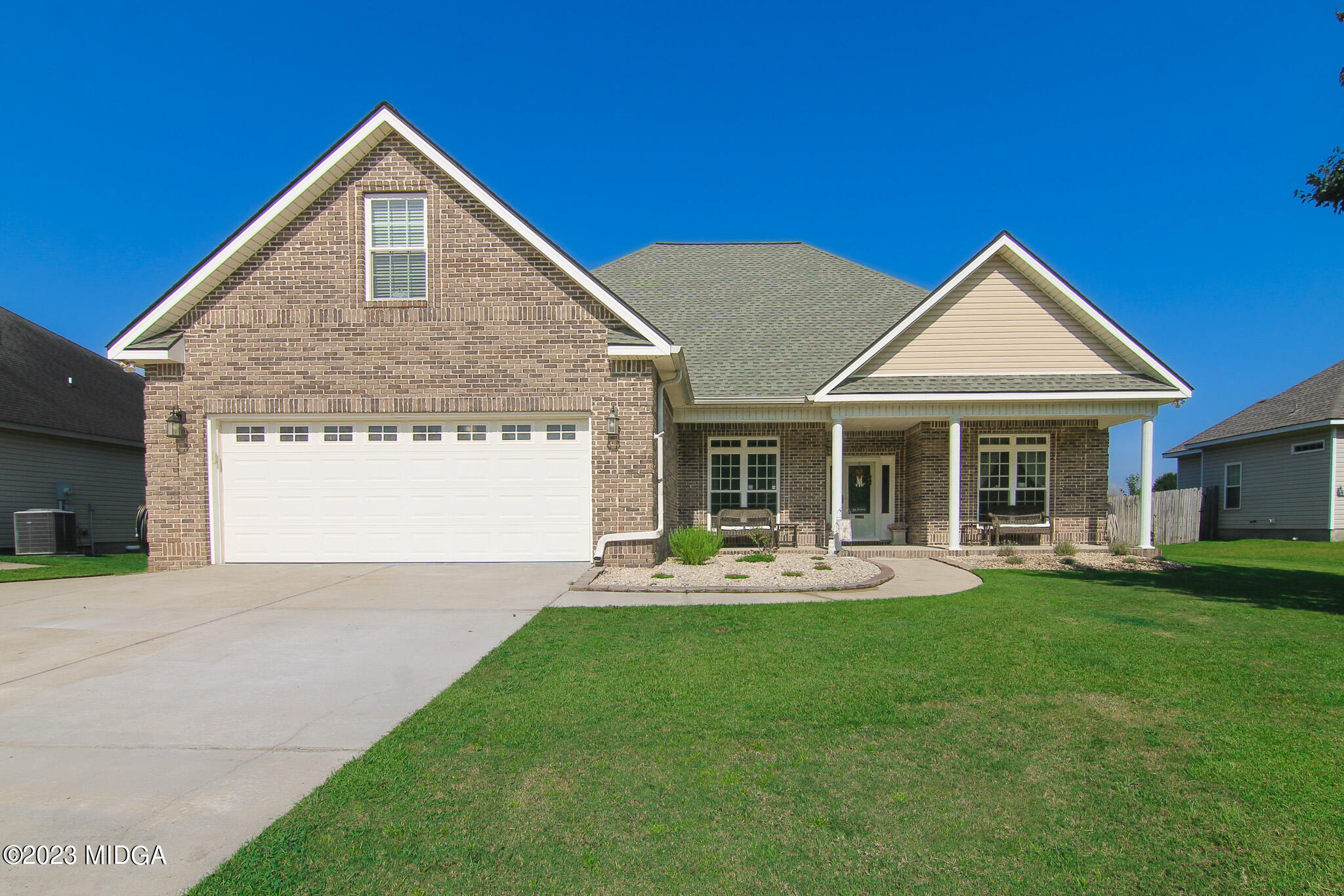 a front view of a house with a garden and plants