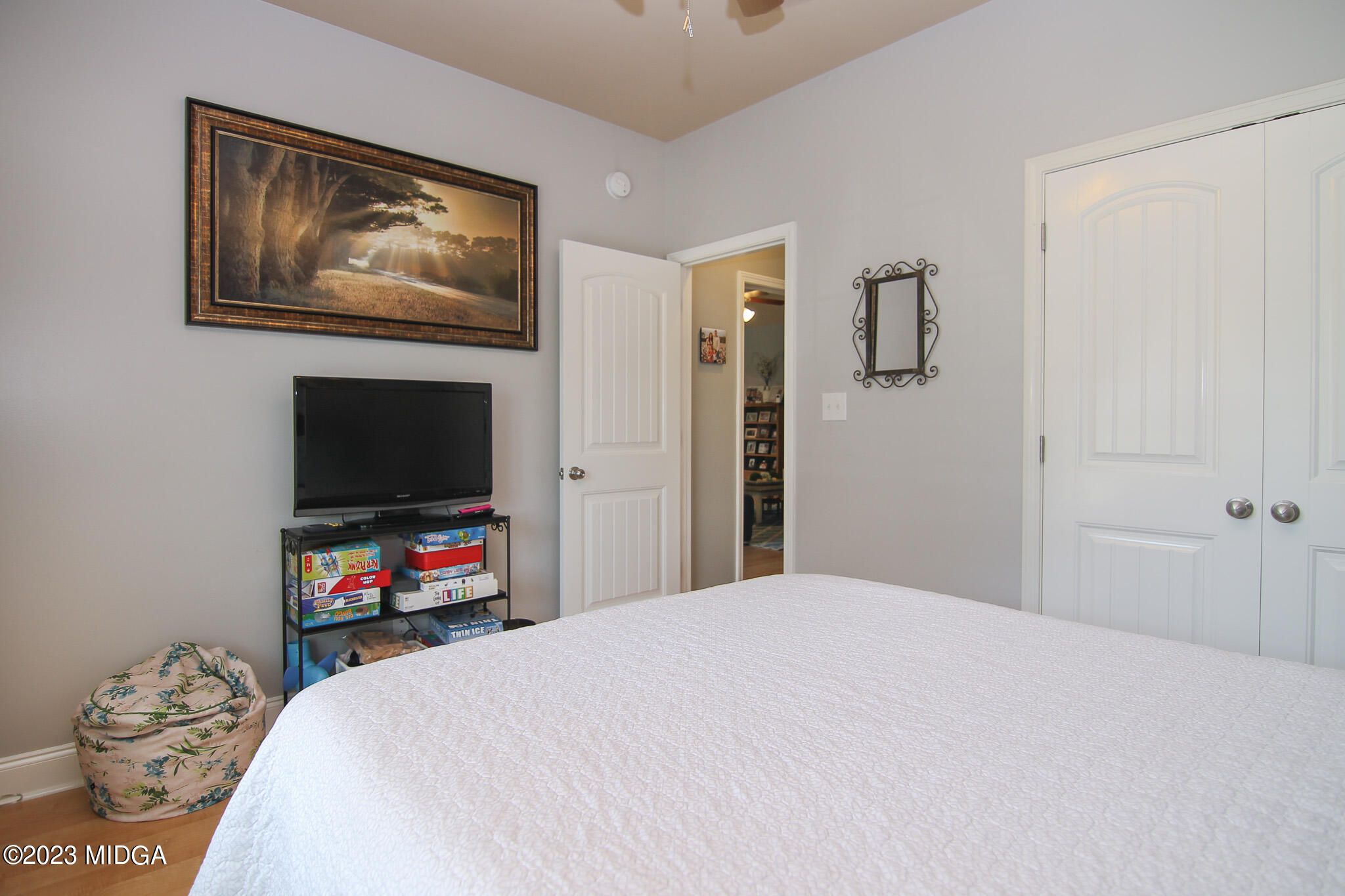 110 Berkley Circle Warner Robins, GA 31093 - Photo 30 of 57 a bedroom with a bed a mirror and a flat tv screen on dresser