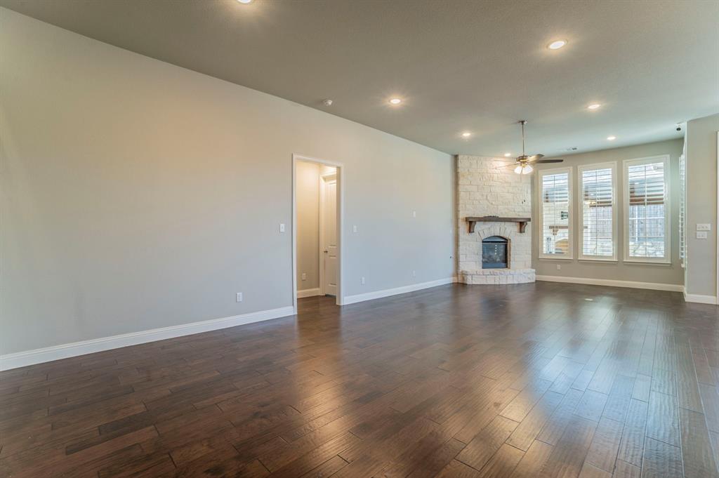 3503 Jersey Road Melissa, TX 75454 - Photo 16 of 40 Unfurnished living room with dark wood finished floors, a stone fireplace, recessed lighting, and ceiling fan