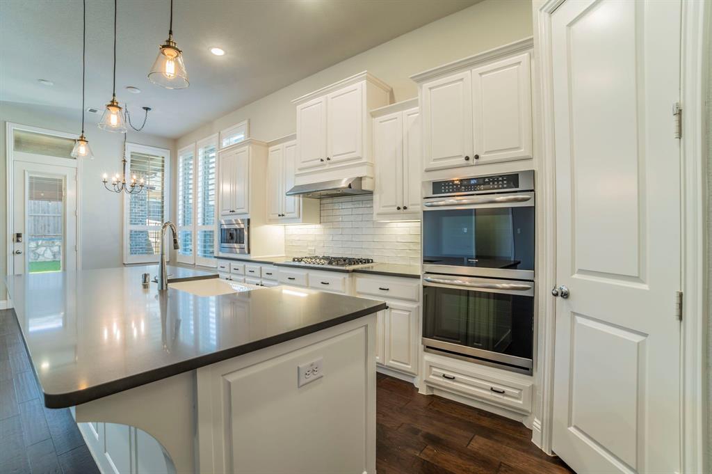 3503 Jersey Road Melissa, TX 75454 - Photo 20 of 40 Kitchen featuring stainless steel appliances, a kitchen island with sink, pendant lighting, white cabinetry, and tasteful backsplash
