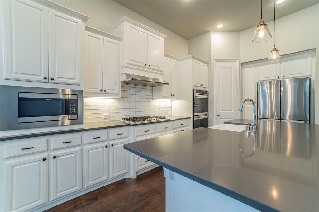 3503 Jersey Road Melissa, TX 75454 - Photo 21 of 40 Kitchen with decorative light fixtures, white cabinetry, appliances with stainless steel finishes, decorative backsplash, and dark wood-style floors