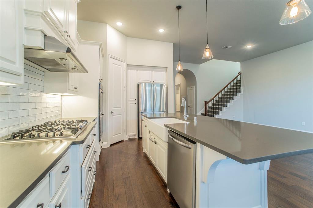 3503 Jersey Road Melissa, TX 75454 - Photo 22 of 40 Kitchen with arched walkways, decorative backsplash, stainless steel appliances, pendant lighting, and white cabinetry