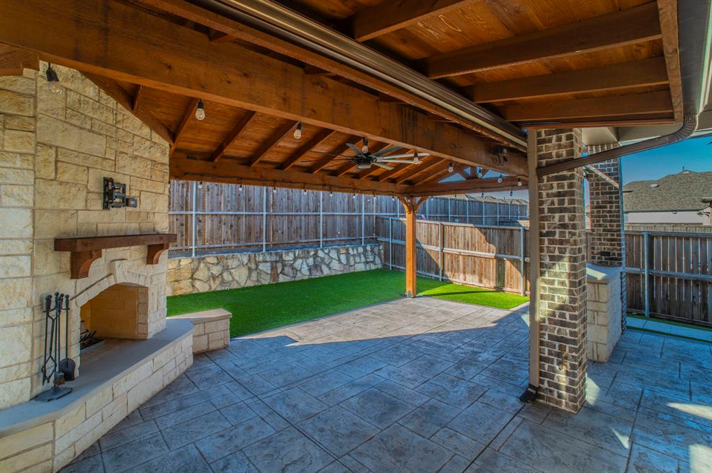 3503 Jersey Road Melissa, TX 75454 - Photo 37 of 40 Fenced backyard with a ceiling fan, a patio, and an outdoor stone fireplace