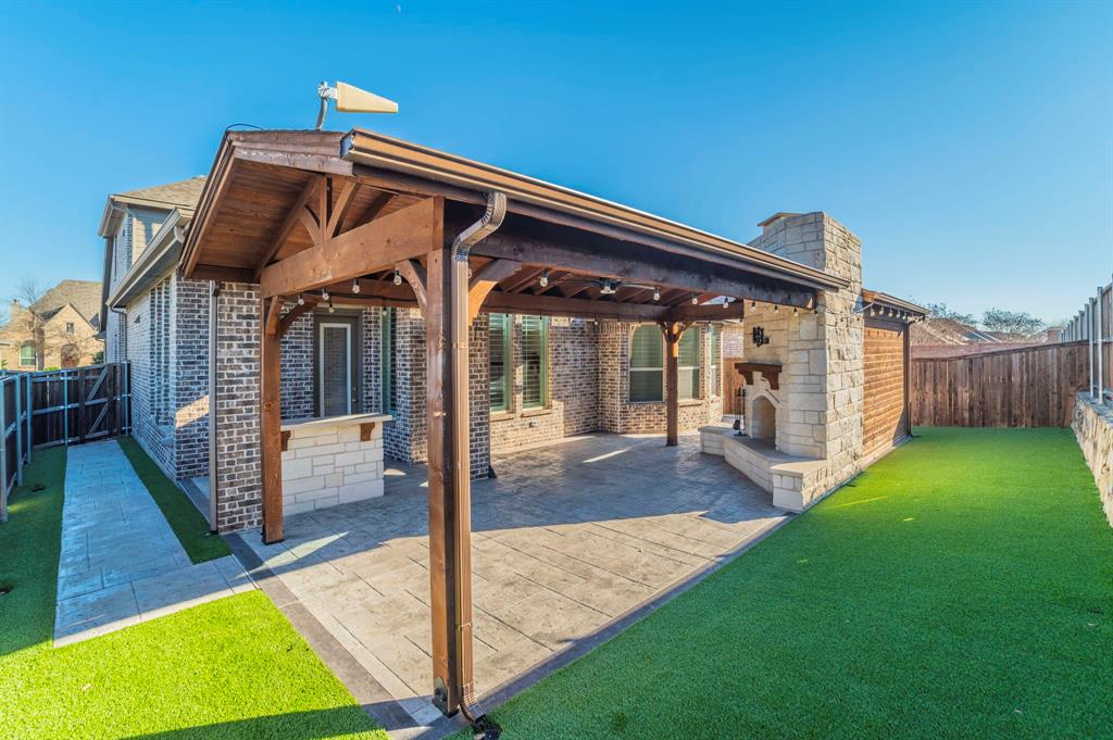 3503 Jersey Road Melissa, TX 75454 - Photo 38 of 40 Rear view of property with an outdoor stone fireplace, a fenced backyard, a patio, a chimney, and brick siding