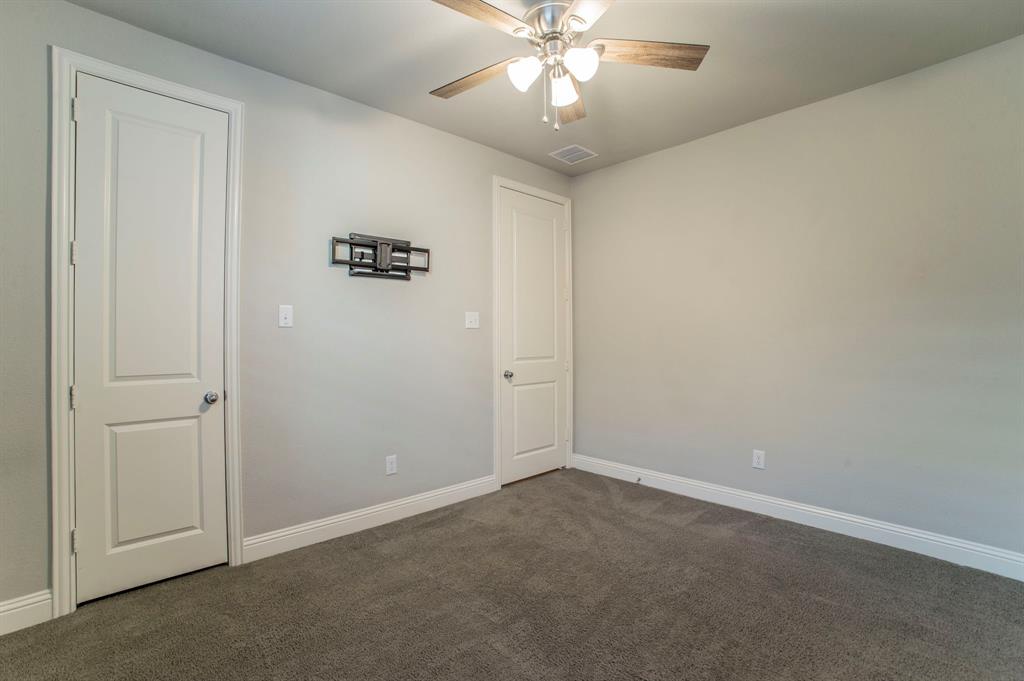 3503 Jersey Road Melissa, TX 75454 - Photo 8 of 40 Empty room with dark carpet and a ceiling fan