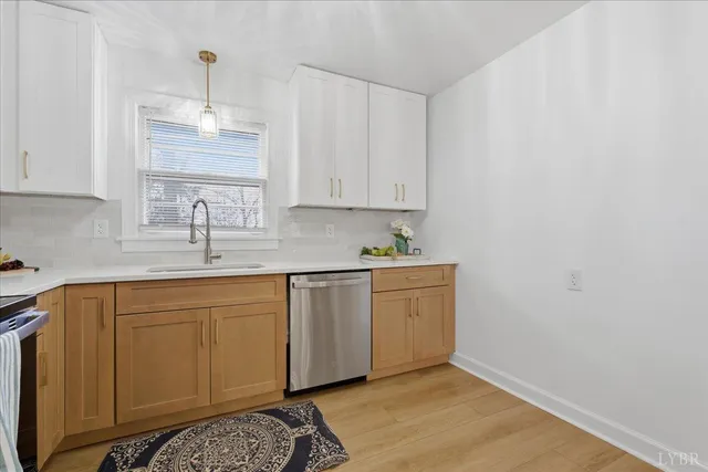 a kitchen with stainless steel appliances granite countertop white cabinets and a stove top oven