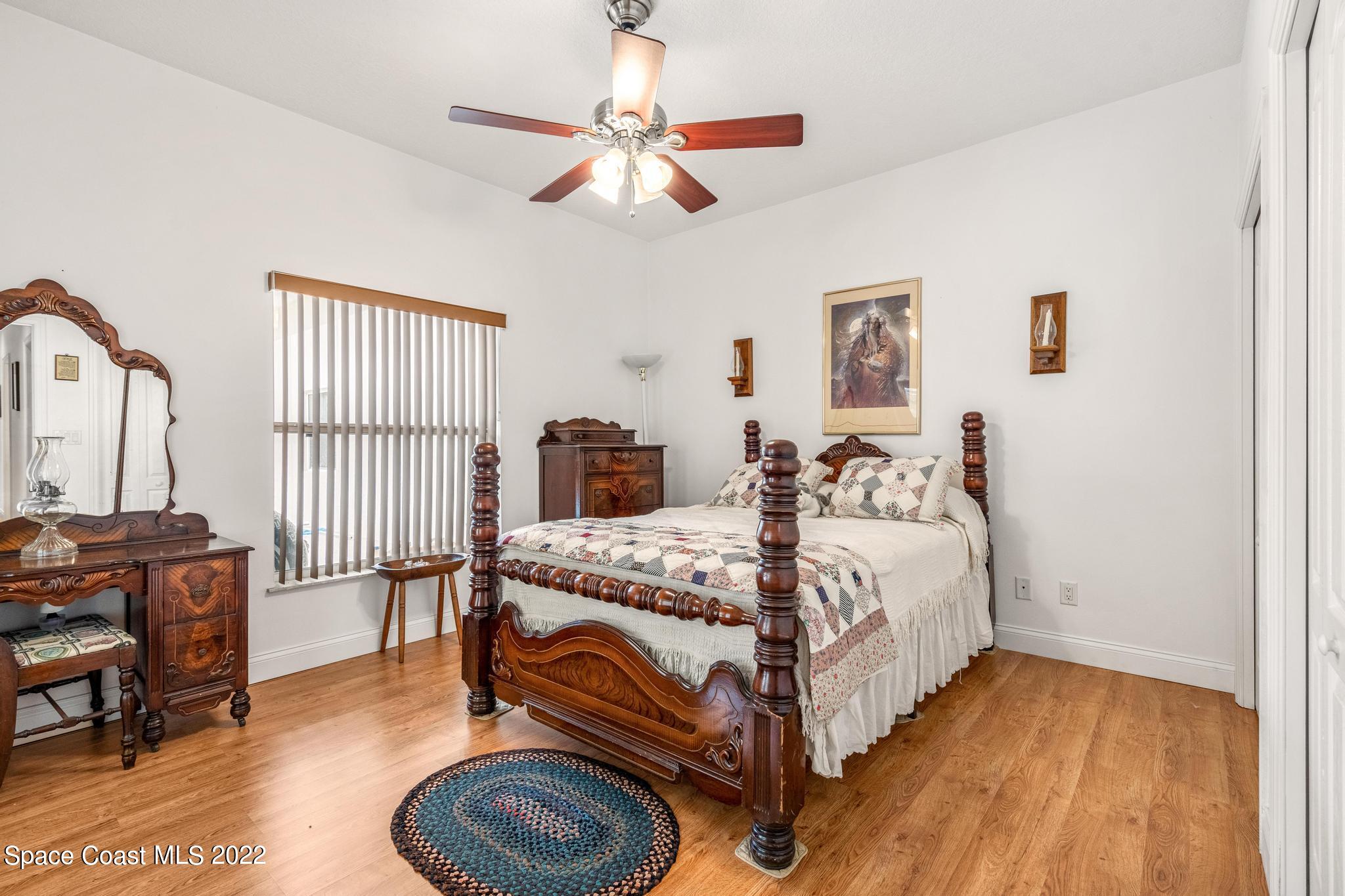 3970 Harlock Road Melbourne, FL 32934 - Photo 14 of 30 a bed room with a bed and a chandelier