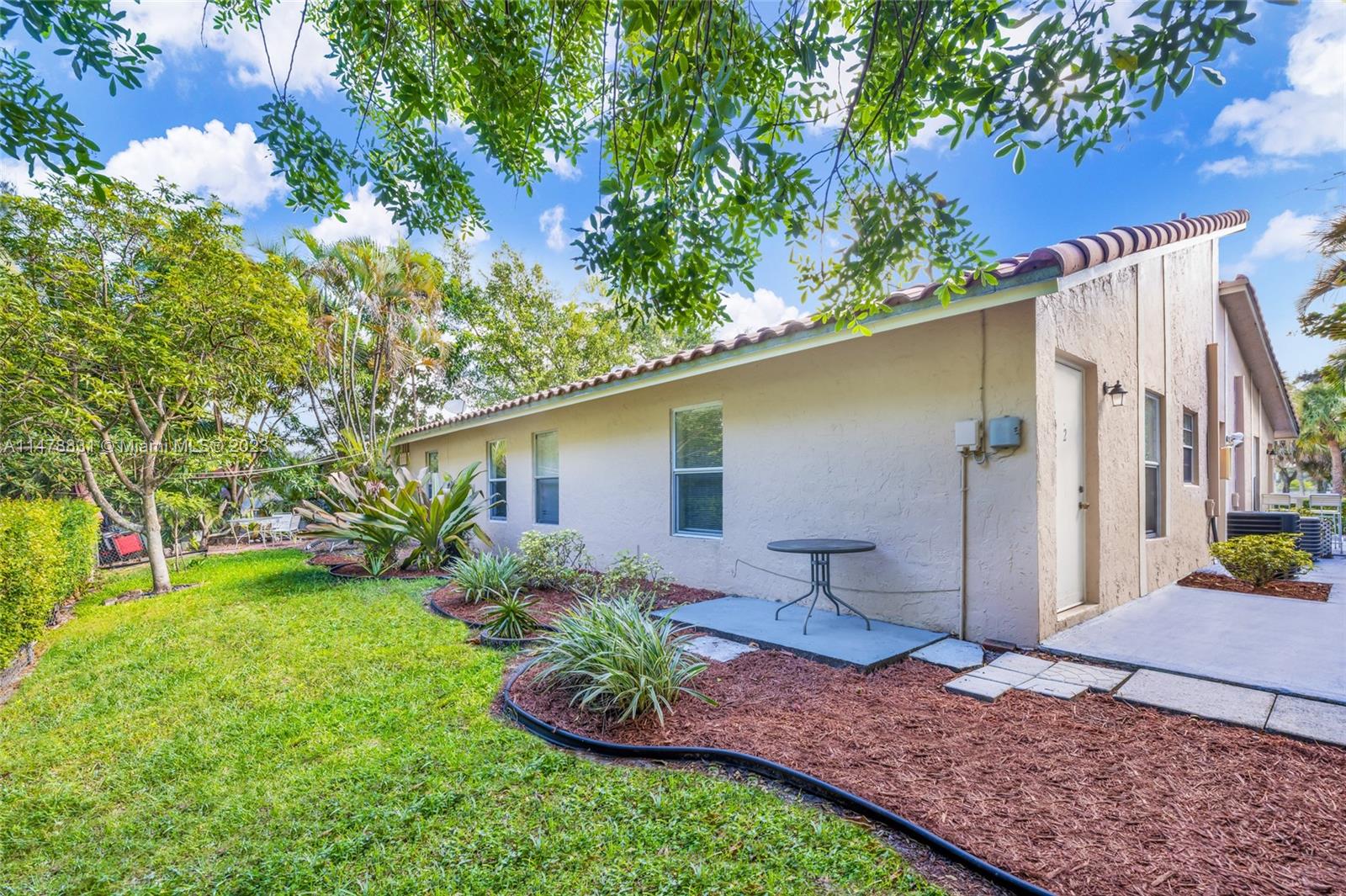 3504 Riverside Drive Coral Springs, FL 33065 - Photo 5 of 33 a view of a backyard with potted plants and large tree