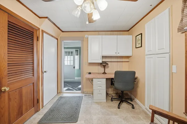 a view of a workspace with furniture and a window
