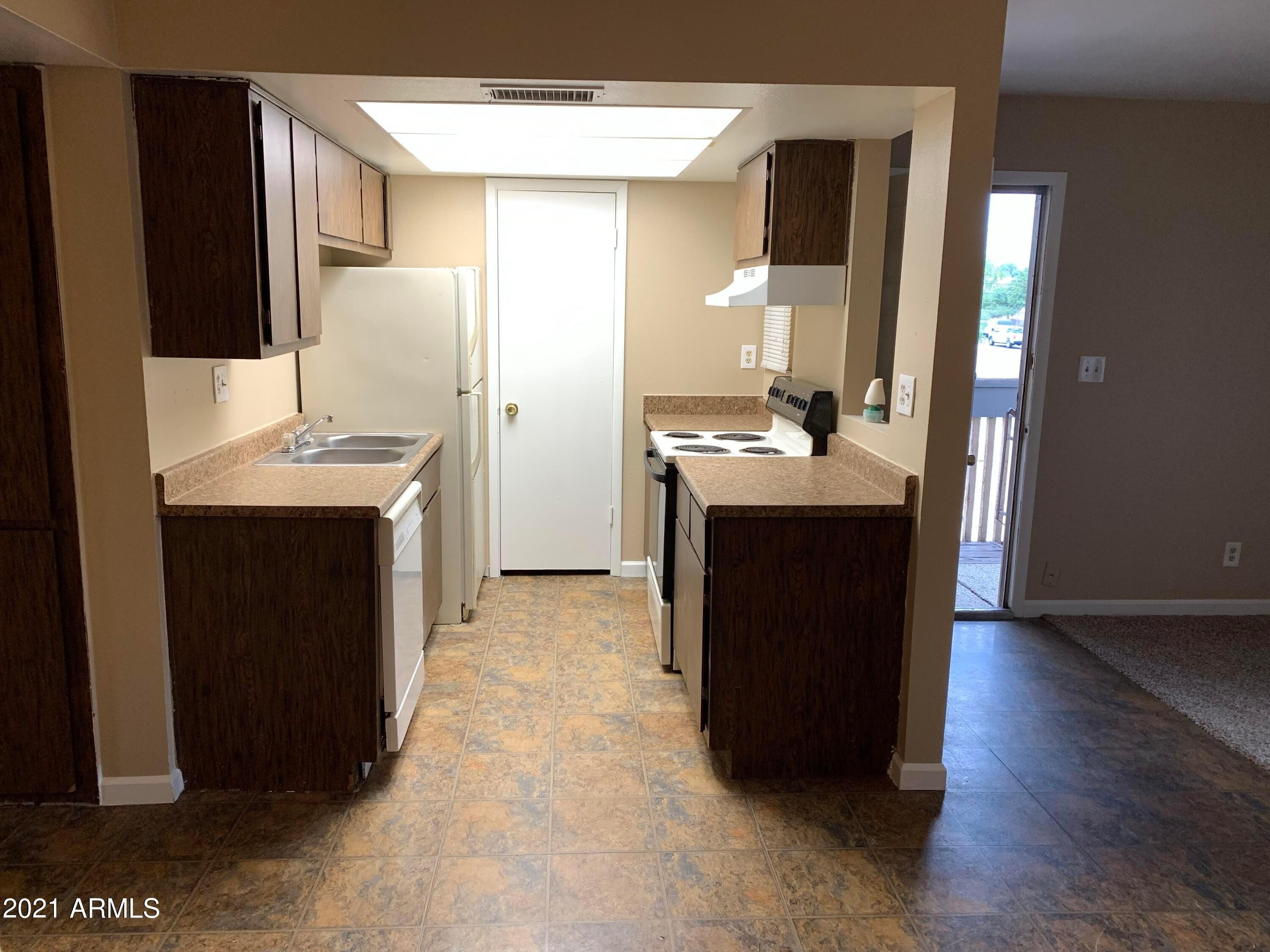 2217 East Cactus Road, Unit 4 Phoenix, AZ 85022 - Photo 3 of 14 a kitchen with a sink and a refrigerator