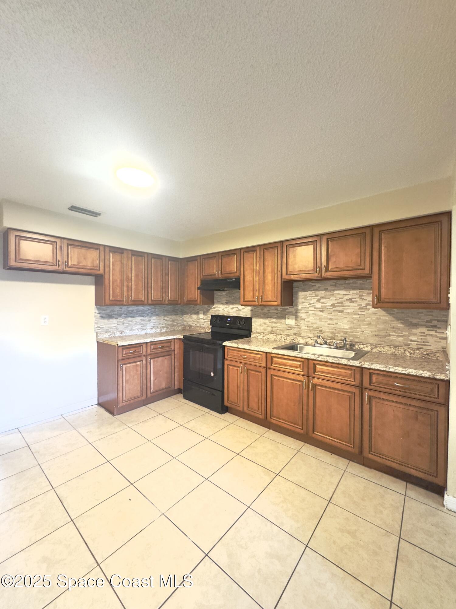 2466 Uranus Drive Cocoa, FL 32926 - Photo 14 of 20 a kitchen with stainless steel appliances granite countertop a sink and cabinets