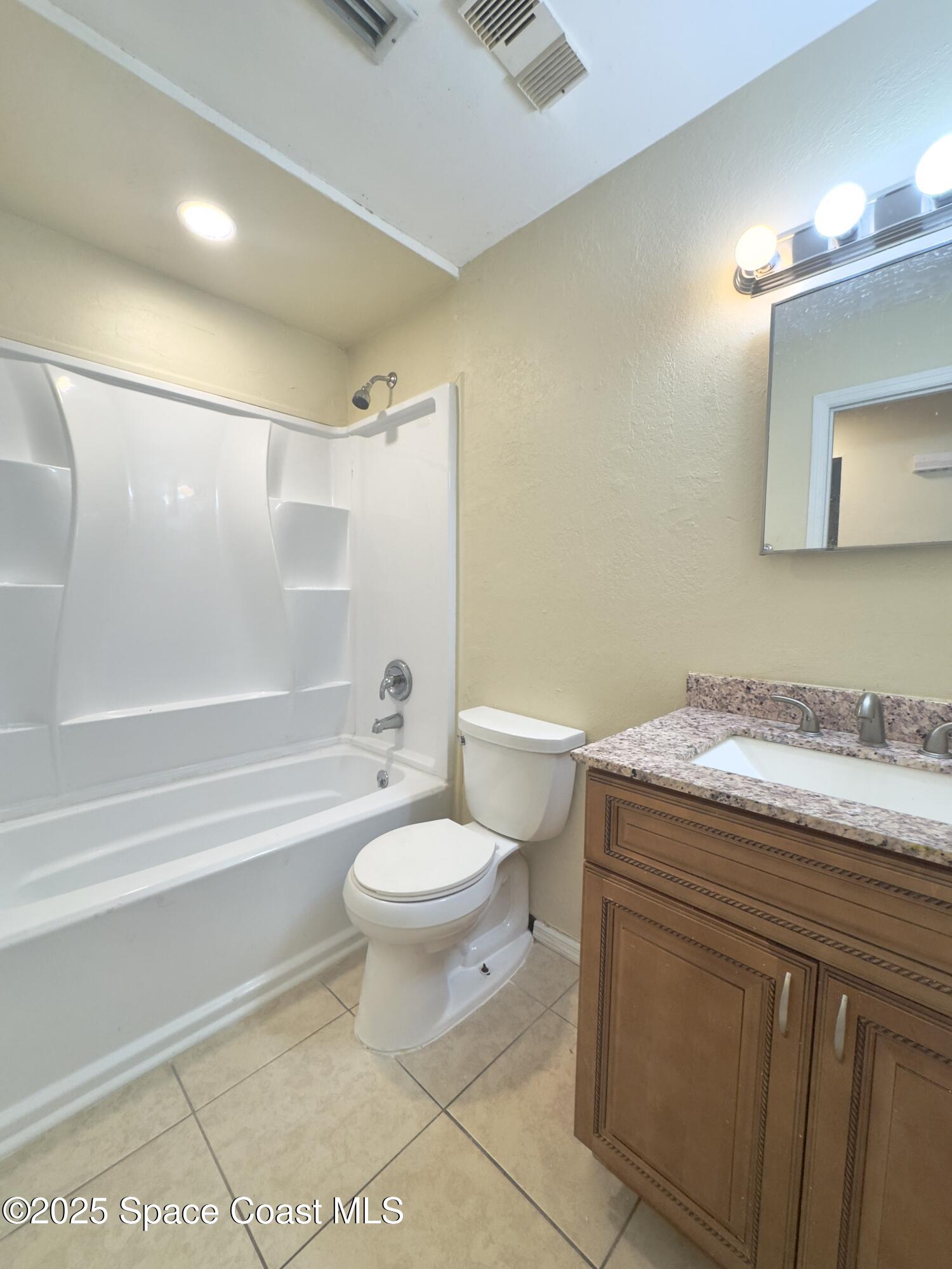 2466 Uranus Drive Cocoa, FL 32926 - Photo 10 of 20 a bathroom with a granite countertop sink toilet mirror and bathtub